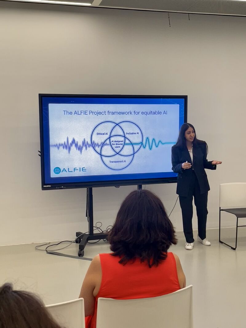 Here is a short alt text in English: > Reyhaneh presenting a slide titled "The ALFIE Project framework for equitable AI," featuring a Venn diagram with pillars for Ethical AI, Inclusive AI, and Transparent AI.